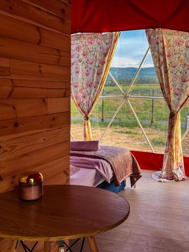 a room with a table and a large window at Glamping Izerska Bajka in Mirsk