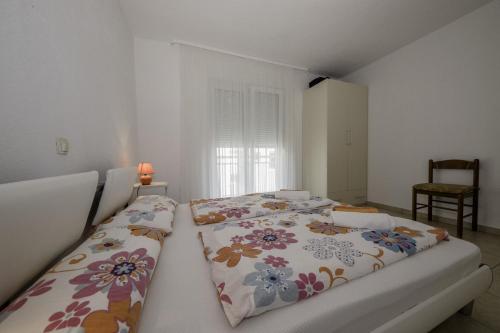 a bedroom with two beds with floral pillows at Apartmani Leovac in Lopar