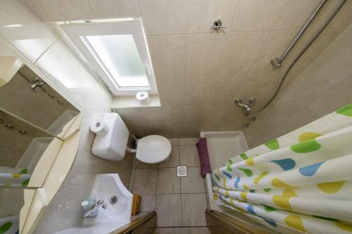 a bathroom with a toilet and a sink and a mirror at Apartmani Leovac in Lopar