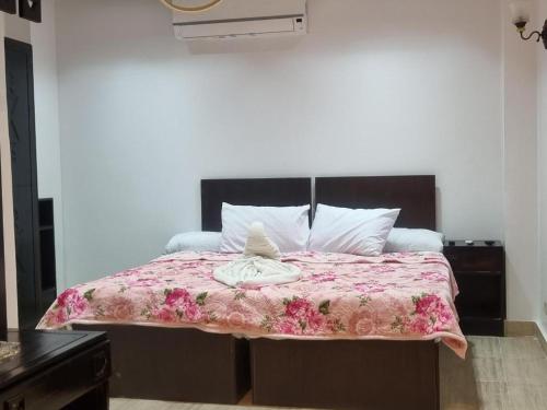 a bed with a pink blanket and white pillows at Summer Land Hotel in Abu Simbel