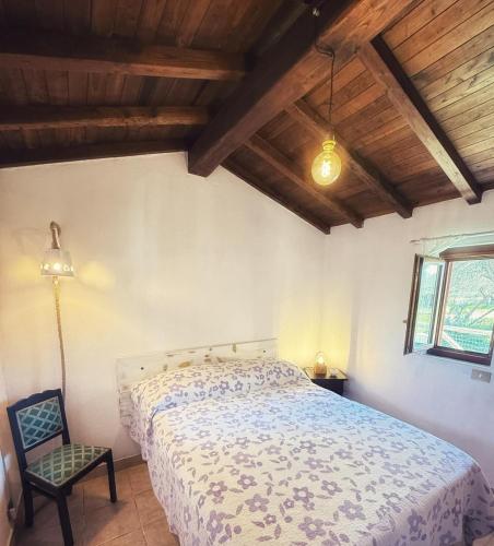 a bedroom with a bed and a chair and a window at alloggio turistico Castel di Salce in Viterbo