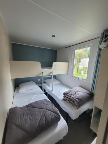a bedroom with two beds and a window at Mobil-home MJ in Seignosse