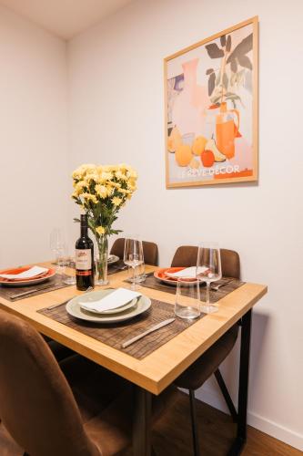 a wooden table with wine glasses and a vase of flowers at Waldblick am Ring in Kelberg