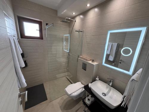 a bathroom with a sink and a toilet and a mirror at Boka Hub Apartments in Krašići