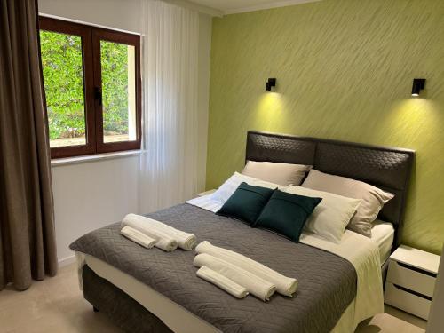 a bedroom with a large bed with two towels on it at Boka Hub Apartments in Krašići