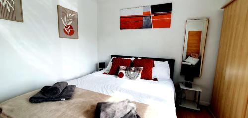 a bedroom with a white bed with red pillows at Reigate - 1 Bed by Mobius Property Solutions in Reigate