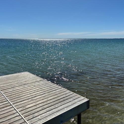 a wooden dock in the middle of a body of water at Strandvænge 12, 4600 Køge in Køge