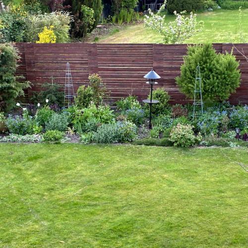 a garden with a wooden fence and some plants at Strandvænge 12, 4600 Køge in Køge
