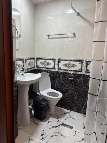 a bathroom with a toilet and a sink at Lucy Guest House in Garni