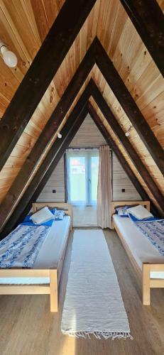 a attic bedroom with two beds and a window at Agin Konak in Gusinje