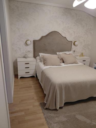 a bedroom with a large bed with a large headboard at A casa de Aliciña in Sanxenxo