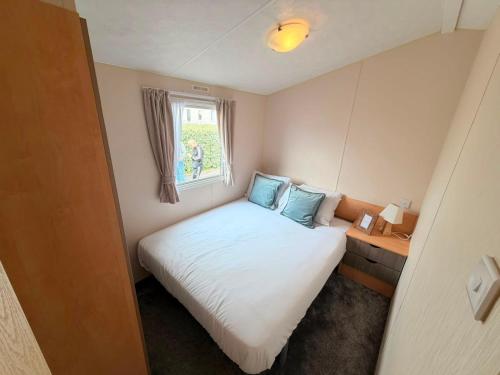 a small bedroom with a bed and a window at Magnolia in Porthcawl
