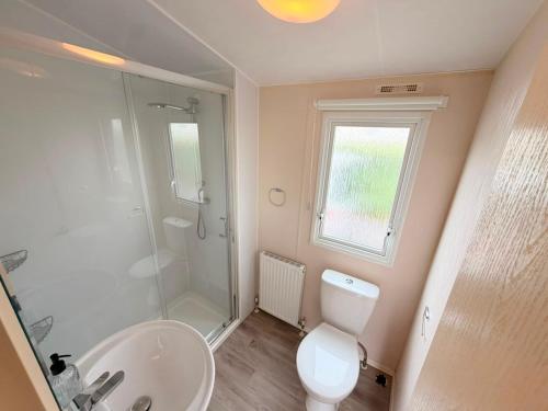 a bathroom with a shower and a toilet and a sink at Magnolia in Porthcawl
