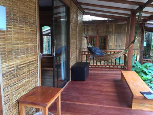a porch with a hammock on a house at Phoxay Ngam Resort in Vang Vieng