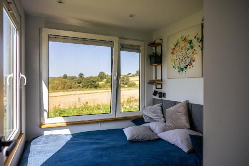 a bedroom with a bed and a large window at Slow Box Apartament z pieknym widokiem in Pawłów