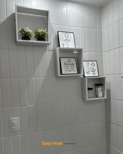 a bathroom with two shelves on the wall with plants at Simple Smart Residence Manaíra - By EasyHost in Tambaú