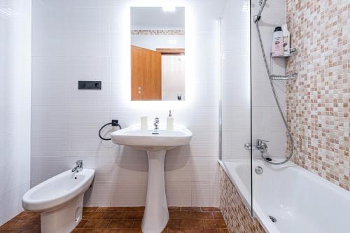 a white bathroom with a sink and a shower at Bright & Spacious Apartment in Nerja Centre in Nerja