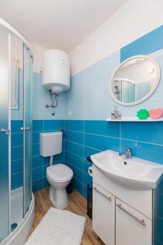 a blue bathroom with a toilet and a sink at Kuća Lucija in Supetar