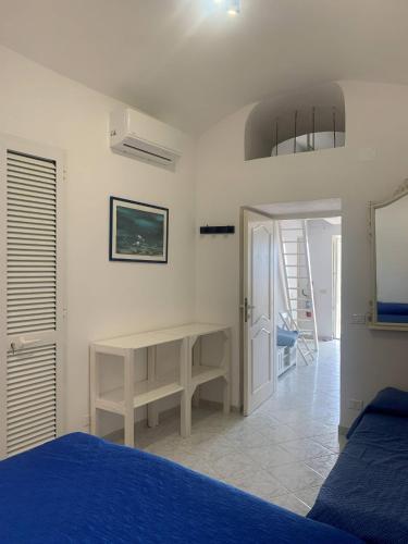a bedroom with a blue bed and a desk at Casa Il Timone Indipendente in Ponza