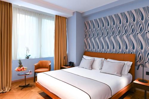 a bedroom with a large bed and a chair at Hotel Astoria in Rapallo
