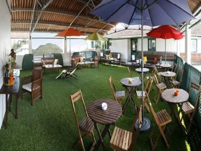 a restaurant with tables and chairs and an umbrella at Hôtel Stella in Lourdes