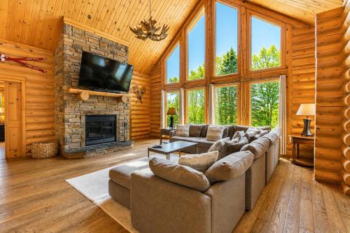 a living room with a couch and a fireplace at Fiddler Lake Resort - Moose 93 in Mille-Isles