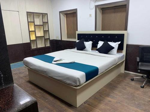 a bedroom with a large bed with blue and white pillows at Hotel O The Diamond Palace in Kolkata