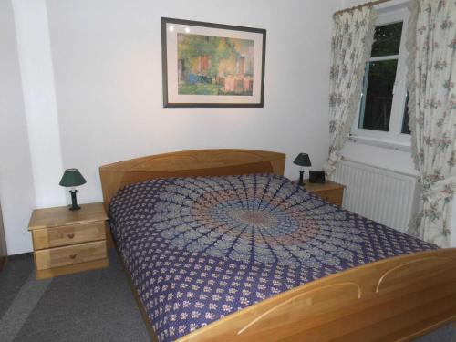 a bedroom with a bed and two night stands and a window at 54 Appartement Residenz Bellevue U in Zinnowitz