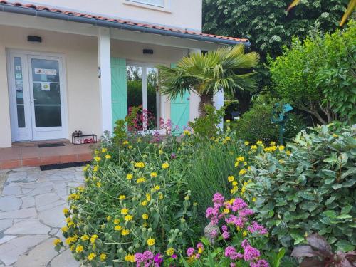 a garden with flowers in front of a house at Maison venitia t5 in Aussonne