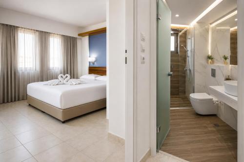 a hotel room with a bed and a bathroom at Mary Hotel & Mary Royal Suites in Platanes