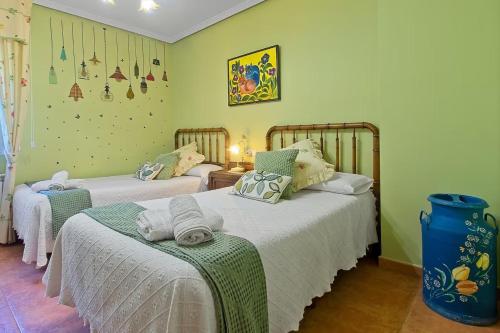 two beds in a room with green walls at La Cuadra in Cabornera