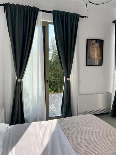 a bedroom with a bed and a large window at SunkissedVilla in Draç