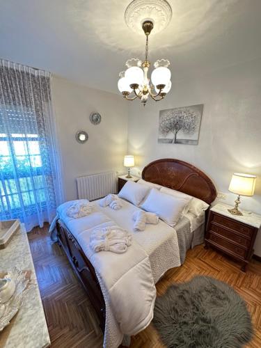 a bedroom with a large bed and a chandelier at Casa da Rapadoira in Laxoso de Abaixo