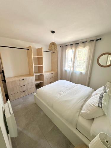 a bedroom with a large white bed and a mirror at Cala Serena Saint Cyprien in Lecci