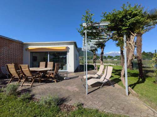 a patio with a table and chairs and an arbor at Casa Fee in Gravedona