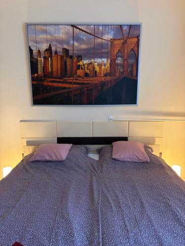 a bedroom with a bed with a picture on the wall at Casa Cristina in Pécs
