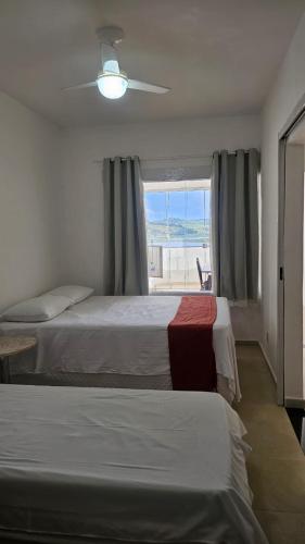 a hotel room with two beds and a window at Lagamar Hotel Varginha in Varginha