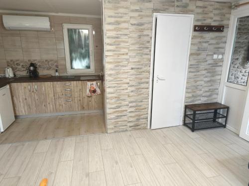 an empty room with a kitchen and a door at Erdőszéli vendégház in Dudar
