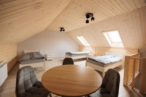 a room with a table and beds in a attic at Agroturystyka Oliweczka 31 in Potok Wielki