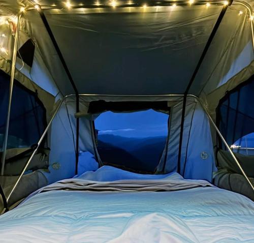a tent with a bed in it with lights at lodi campers rental in Theth