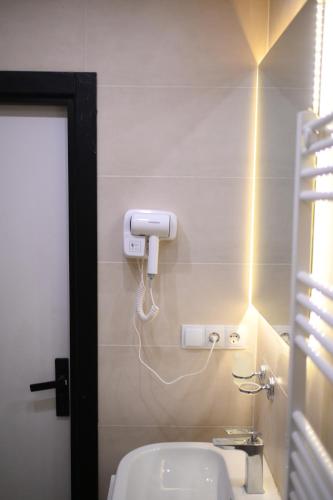 a bathroom with a white toilet and a phone on the wall at Batumi Skynest in Batumi