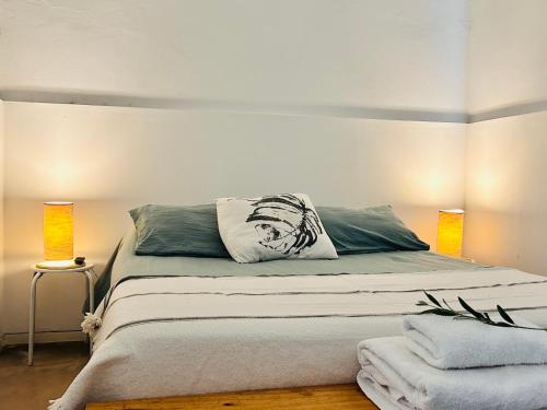 a bedroom with a large bed with two lamps at Los Olivos Apart in Cafayate
