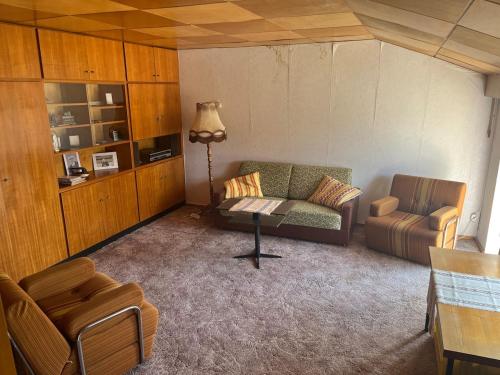 a living room with a couch and a chair at Pure Nostalgie am Scharmützelsee in Wendisch Rietz
