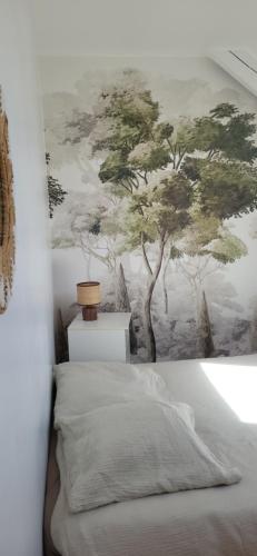 a bedroom with a tree mural on the wall at proche d'Yvetot in Valliquerville