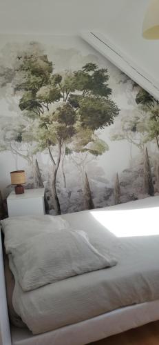 a bedroom with a tree mural on the wall at proche d'Yvetot in Valliquerville