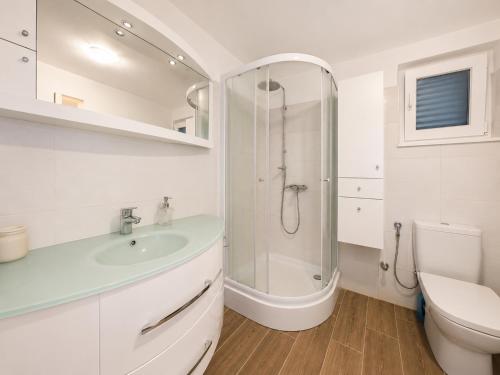 a white bathroom with a sink and a shower at Koko's home in Ston