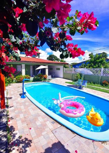 a swimming pool with a person in a float in the water at Pitimbu Beach House Rosi in Pitimbu
