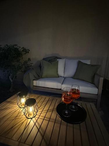 a living room with a couch and two wine glasses on a table at Sea Sky Villa with private pool in Costa Paradiso