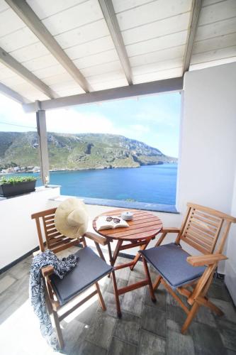 a table and chairs on a balcony with a view of the ocean at Blue horizon apartment & suite in Kalymnos