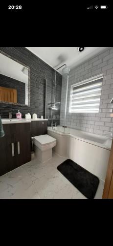 a bathroom with a tub and a toilet and a sink at Saddlebrook 156 in Leysdown-on-Sea